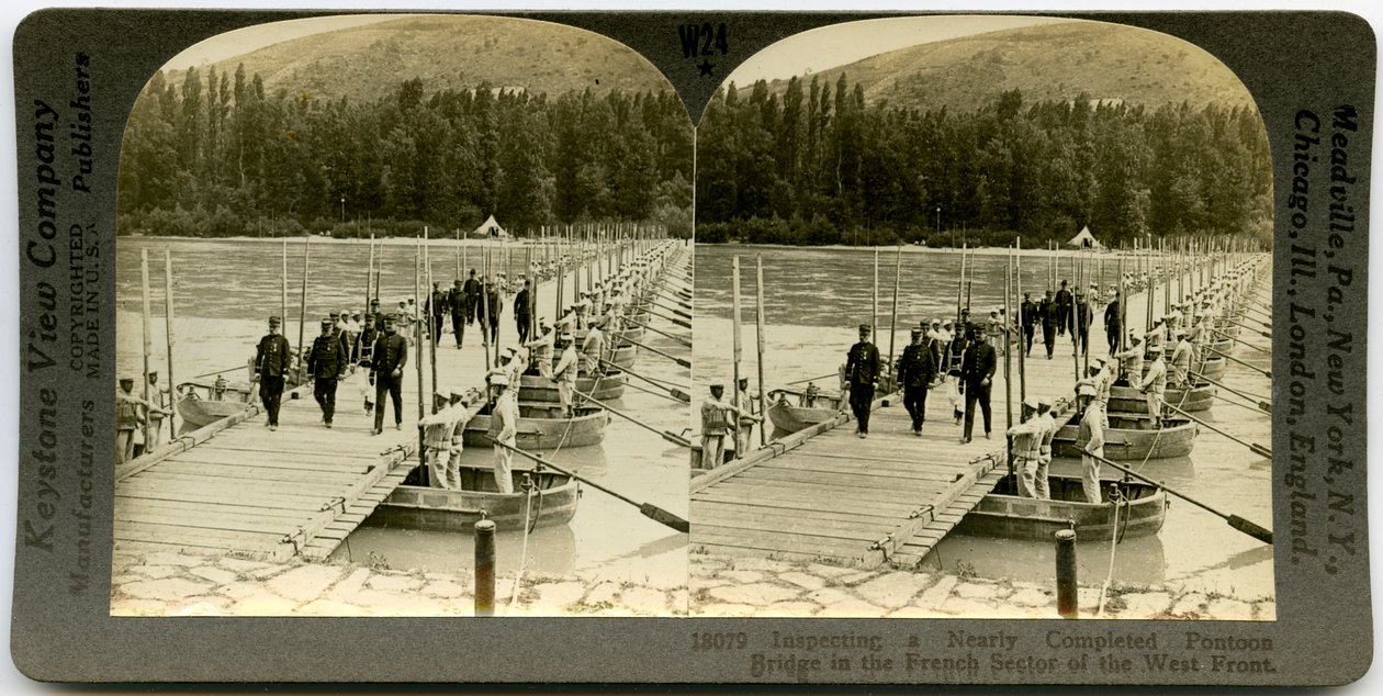 Horisontalt sepia -stereokort, der viser uniformerede betjente, der krydser en pontonbro med mænd, der står i pontonerne på hver side af broen. Keystone stereograf nummer 18079 af Keystone View Company