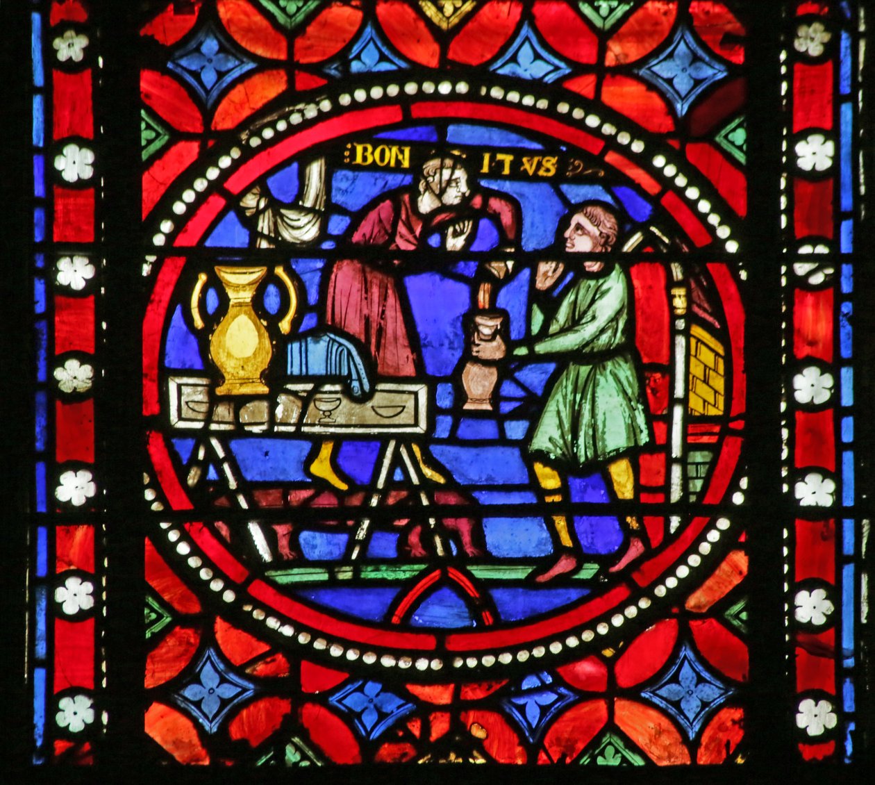 Vindue, der viser Scene fra Saint Bonnets liv: Saint Bonnet, der hælder vin ud af French School