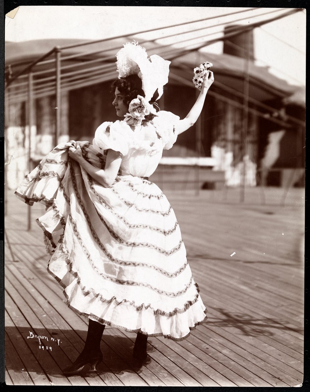 En skuespillerinde i kostume, der øver på taget af det, der sandsynligvis er New York Theatre, New York, 1900 (sølv gelatinetryk) af Byron Company