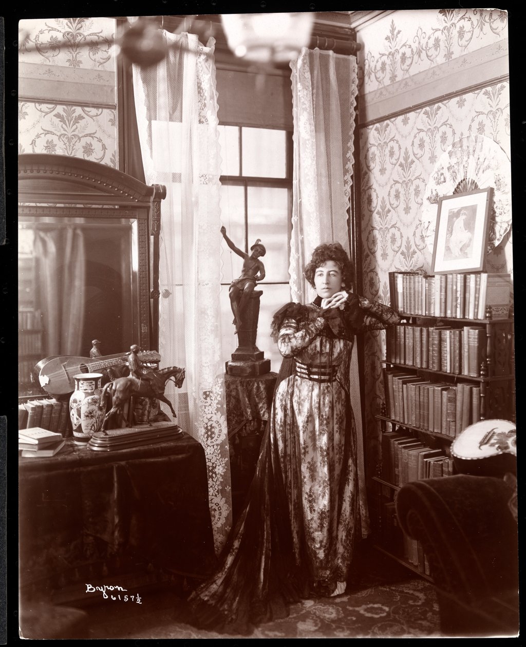 Anita Chartres står i hjørnet af et værelse, ca. 1898 (sølvgelatineprint) af Byron Company