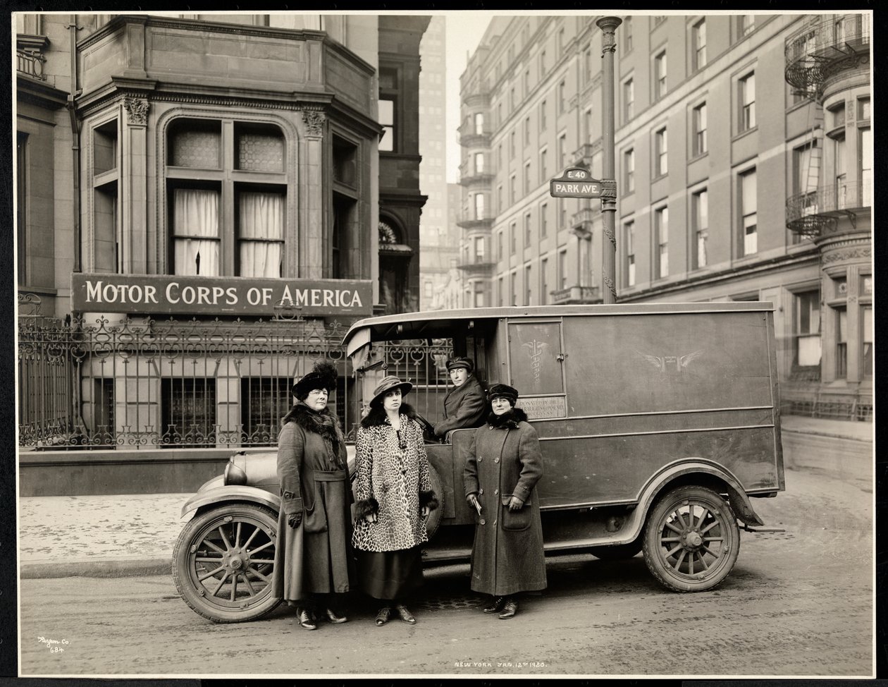 Fire kvinder fra Motor Corps of America står foran en ambulance (en kvinde i førersædet) på Park Avenue på 40th Street foran Motor Corps of America-bygningen, New York, 1920 (s. af Byron Company