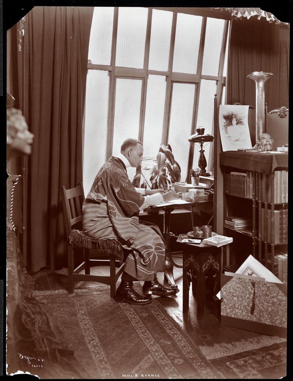 Will R. Barnes i en kappe, siddende ved sit skrivebord i sit studie, 1903 (sølv gelatinetryk) af Byron Company
