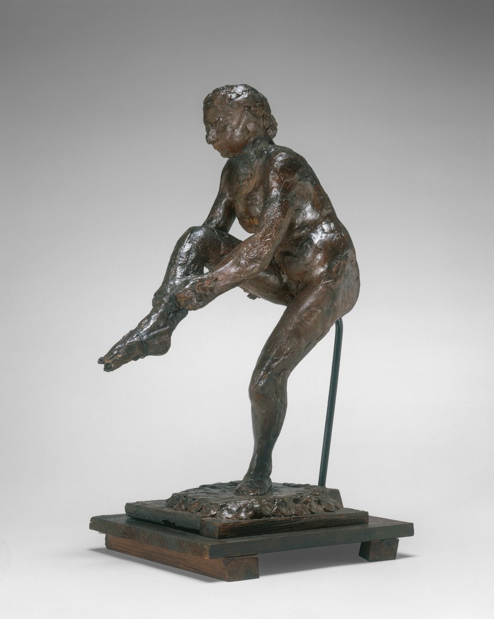 Danser tager sin strømpe på af Edgar Degas