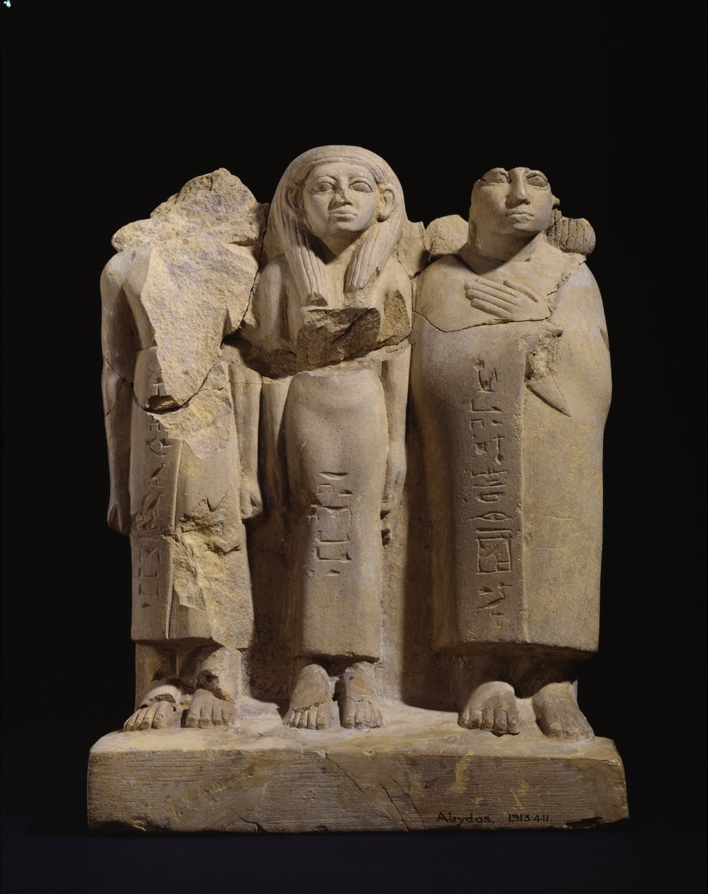 Gruppestatuette af 3 figurer, sent 12. dynasti - tidligt 13. dynasti, ca. 1800-1700 f.Kr. (udskåret gul sandsten med spor af rød og sort maling) af Egyptian