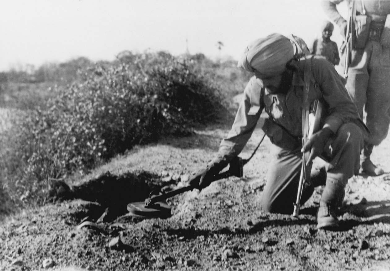 En indisk soldat leder efter miner med en metaldetektor af English Photographer