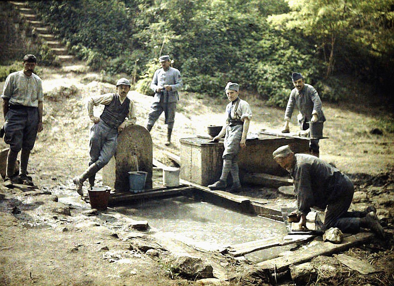 Seks franske soldater med spande og vasketøj ved et springvand, Soissons, Aisne, Frankrig, 1917 (autokrom) af Fernand Cuville