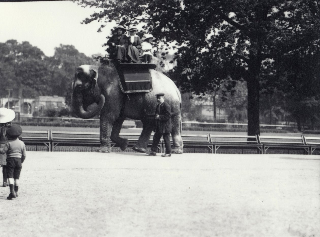 En asiatisk elefant bliver redet af to damer og en ung pige, med en målmand ved sin side, London Zoo, maj 1914 af Frederick William Bond