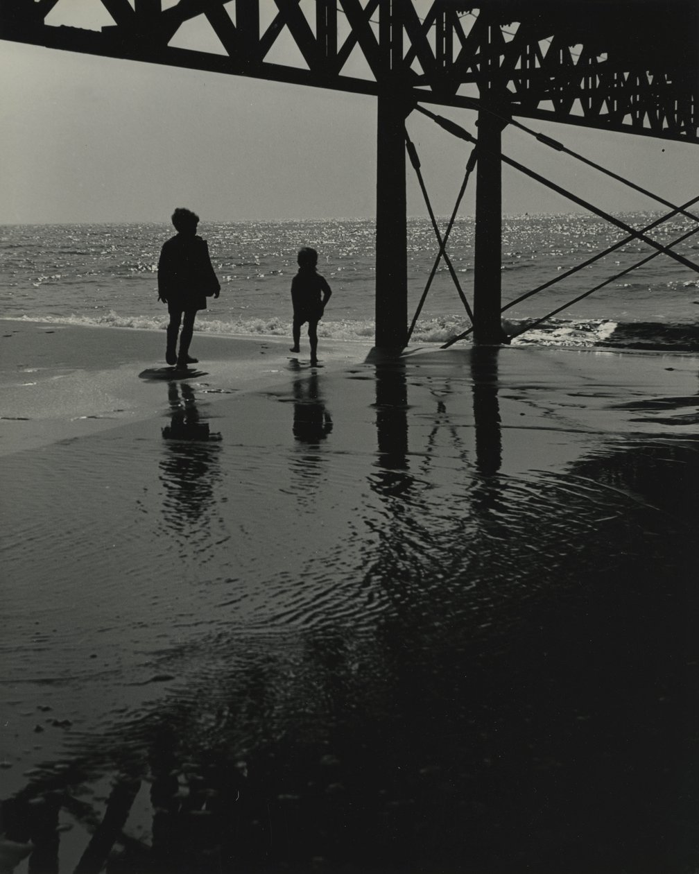 To børn leger på stranden. af Godfrey Macdominic
