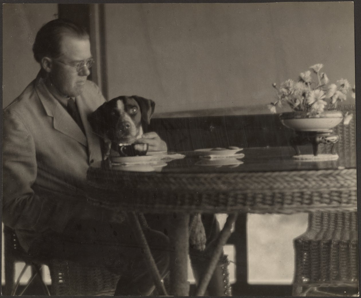 [Mand og hund sidder ved et bord]. af Louis Fleckenstein