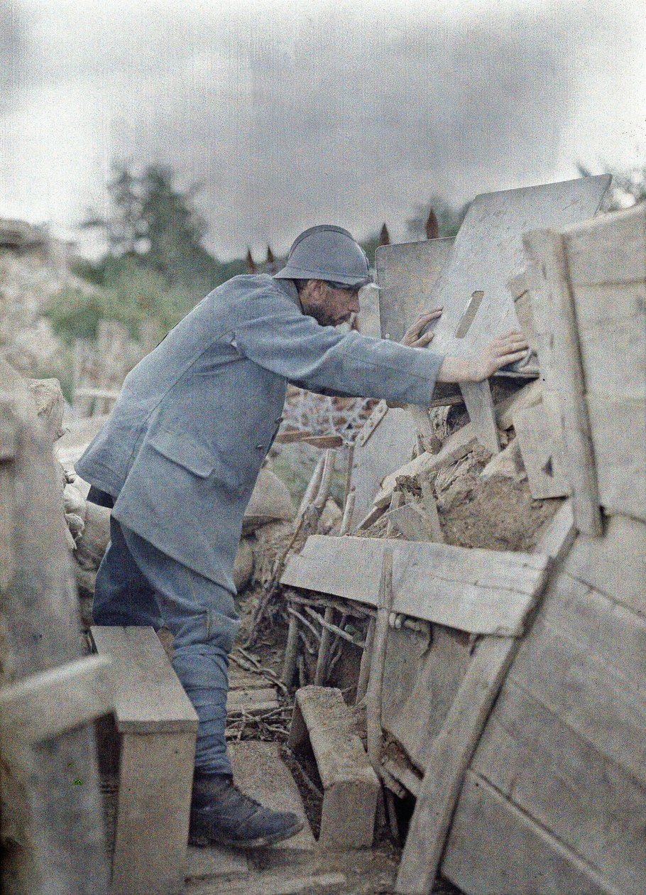 En fransk soldat i hærens udkigspost 26 betragter området foran sig gennem et beskyttende metalskjold, Eglingen, Department Haut-Rhin, Alsace, Frankrig, 26. juni 1917 (autokrom) af Paul Castelnau