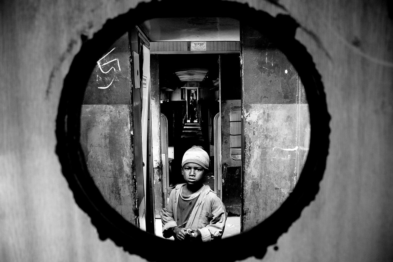 Portræt af et gadebarn set gennem dørhullet i kupéen til et tog på Kamalapur jernbanestation i Dhaka, Bangladesh. 5. januar 2007. af Unbekannt Unbekannt