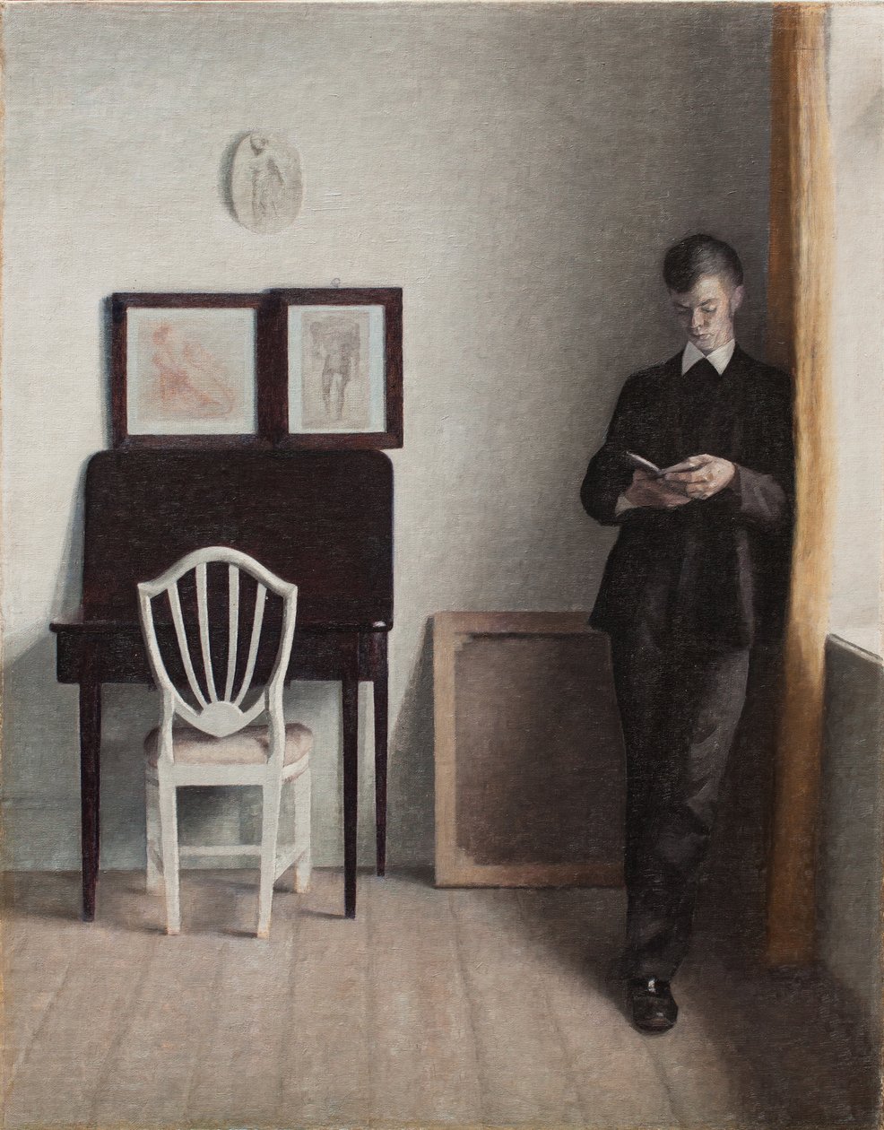 Interiør med en ung mand, der læser af Vilhelm Hammershoi